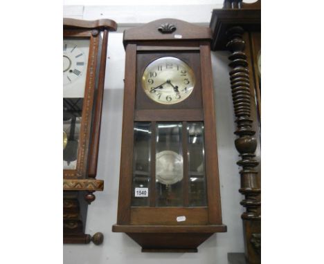 A 1930's oak wall clock with 3 bevelled glass panels