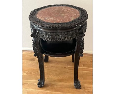 A Chinese ornate red marble topped table on ball and claw feet with shelf under and carved design. (81cm H x 55cm D)