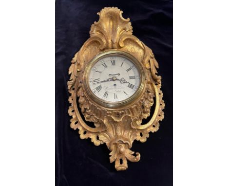 An English carved cartel wall clock. Fusee movement, verge escapement and eight day time piece.