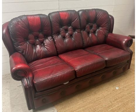 A burnt red leather button back three seater sofa and matching reclining arm chair 
