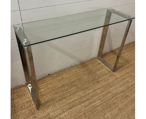 A glass console table on chrome legs (110cm W x 35cm D x 75cm H)