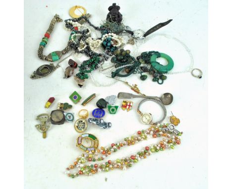 A collection of assorted costume jewellery to include, silver spoon, enamel badges, watches and more. 