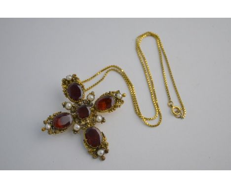 A 19th century Castellani style cross set with oval and square garnets and seed pearls, gilt metal set with brooch fitting an