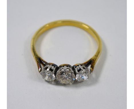 A three-stone diamond ring, the three graduated claw set brilliant cut diamonds in yellow and white metal setting, untested a