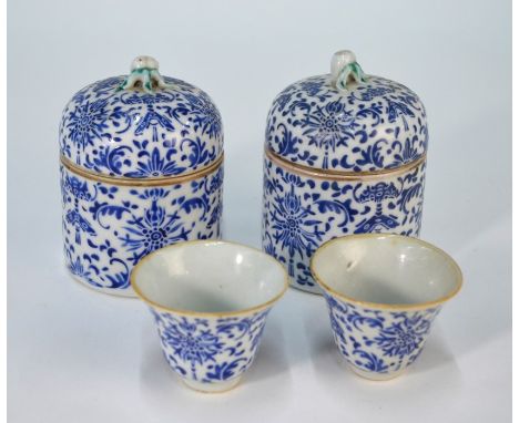 A pair of Chinese blue and white wine cups and lidded warmers with overglaze blue enamel floral and foliate decoration (possi