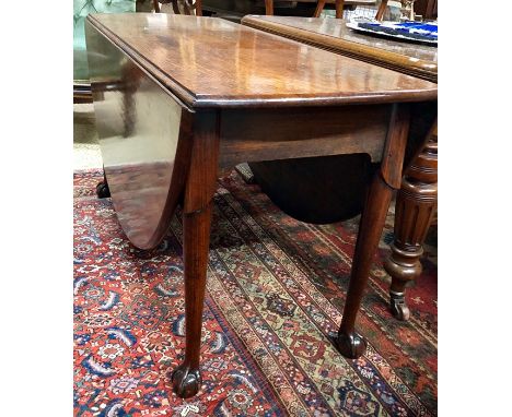 A large George III mahogany drop leaf dining table, the oval top raised on a joint gate-leg frame, the turned legs to claw an