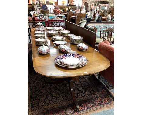 A Victorian style cross-banded mahogany triple pedestal dining table, with three various width leaves, raised on brass castor