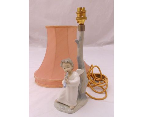 A Lladró figural lamp stand in the form of a putti playing a flute to include a shade, 32cm (h)