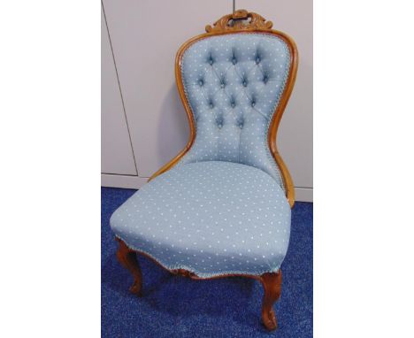 An upholstered button back mahogany ladies chair on cabriole legs and castors
