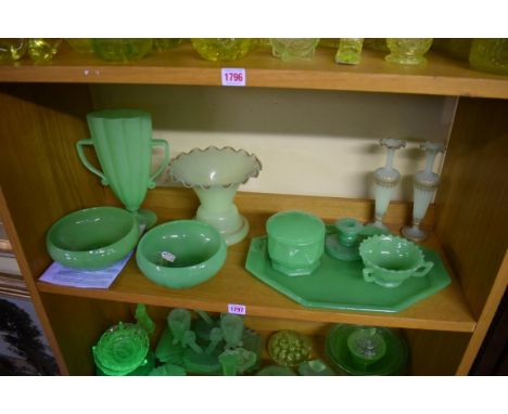 A collection of opaque green uranium glass.&nbsp;(One shelf) 