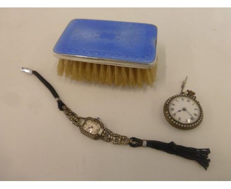 A lady's wristwatch  inlaid with marcasite, a silver and enamel fob watch and a silver and enamel backed hairbrush.