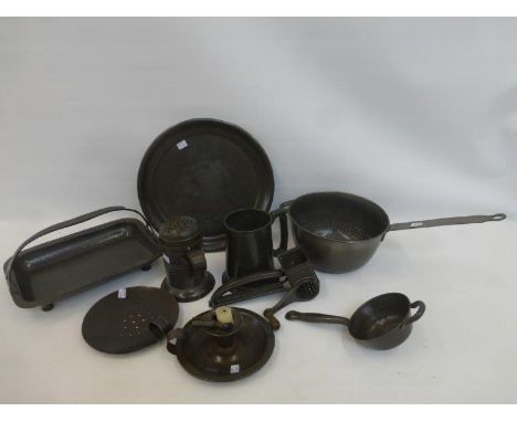 An assortment of kitchenalia including a pincer chamber stick and a lion pewter hand beaten dish with carrying handle.