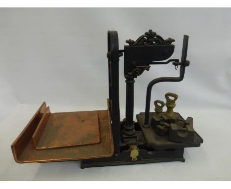 A set of late 19th Century/early 20th Century balance scales with copper pans and an assortment of weights.
