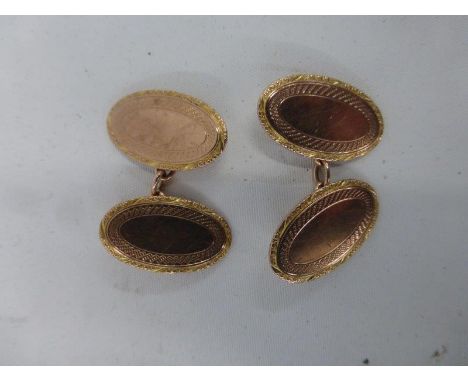 A cased pair of 9ct gold oval cufflinks with engine turned decoration.