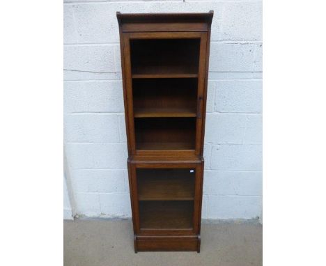 An oak Globe Wernicke style glazed bookcase of small proportions, the upper section of two fixed shelves above a lower sectio