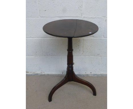 A Georgian mahogany circular tripod wine table, raised on a turned column to outswept supports.