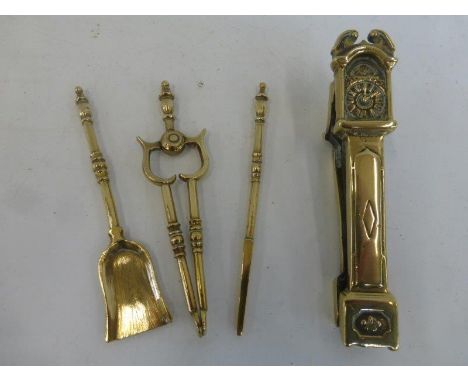 A set of three miniature brass fire tools and a brass pair of nut crackers in the form of a longcase clock.