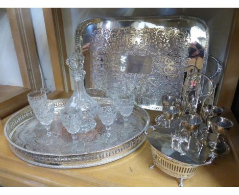 Two silver plated galleried trays, a six setting silver plated egg cup holders, a lidded basket, and a glass decanter with si