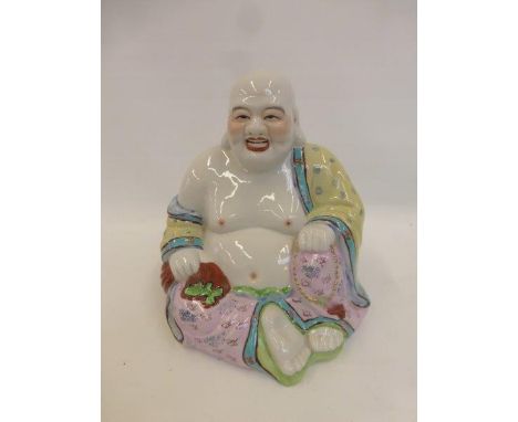 A large ceramic figurine of a seated laughing Buddha.