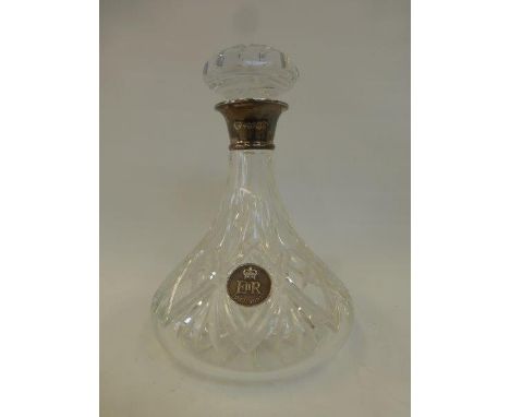 A silver mounted glass Queen's Jubilee decanter, the body inset with a silver coin.