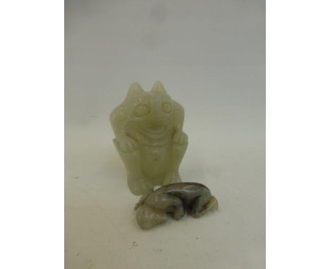 A Chinese carved white jade mythical beast, and a Chinese carved white jade netsuke in the form of a monkey carrying a bag.