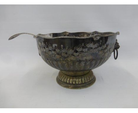 A large silver plated pedestal punch bowl with ring lion head handles and a ladle.
