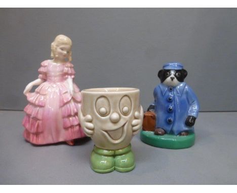 A Wade ceramic figure "Travelling Badger", a Wade Cadbury World egg cup and a Royal Doulton figurine "Rose" HN 1368.