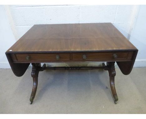 A Regency mahogany sofa table with two frieze drawers, two dummy drawers and D shaped flaps, raised on twin turned supports u