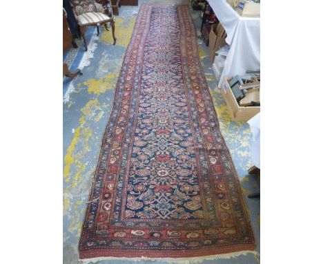 A hand made Eastern runner with multiple border on a light blue and red ground with a geometric design. The central Persian s