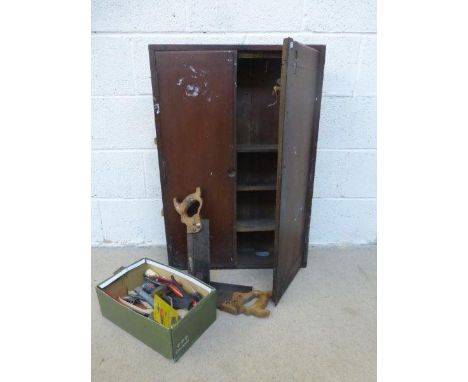 A pitch pine wall hanging tool chest with an assortment of tools.