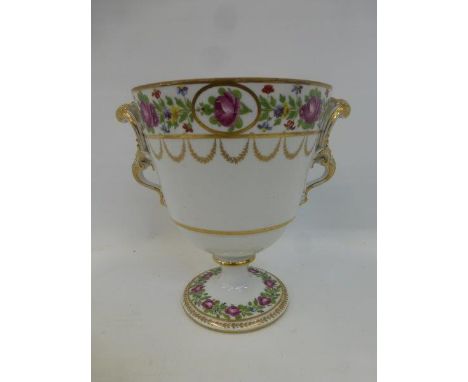 A  large 19th Century ceramic twin handled pedestal urn decorated with roses and garlands.