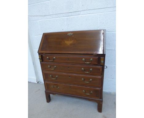 An Edwardian inlaid mahogany bureau, the fall front inlaid with a classical urn enclosing a fitted interior, above four gradu