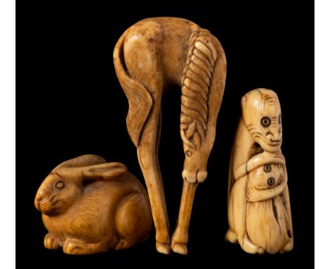 Two Japanese ivory netsuke and a similar okimono: the netsuke in the form of a monkey clutching its young and a crouching rab