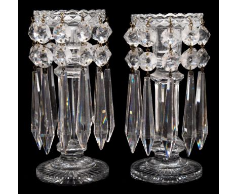 A pair of cut glass table lustres: with circular star cut bases supporting an octagonal column and sconce with a broad and sh