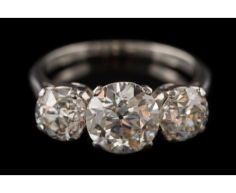 A diamond three-stone ring: the principal old European-cut diamond approximately 7.9mm diameter x 4.6mm deep, estimated to we