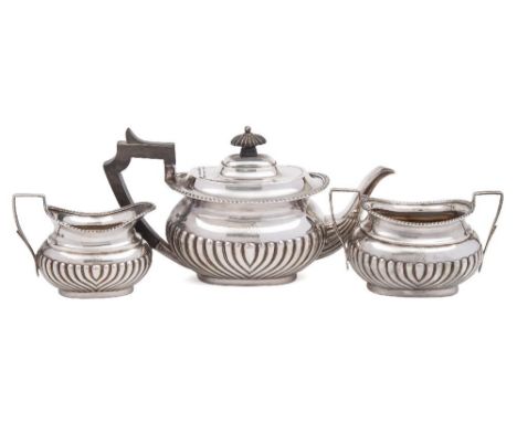 A Victorian bachelor's silver three-piece tea service, maker Henry Atkin, Sheffield, 1898/1900: monogrammed, of barge-shaped 
