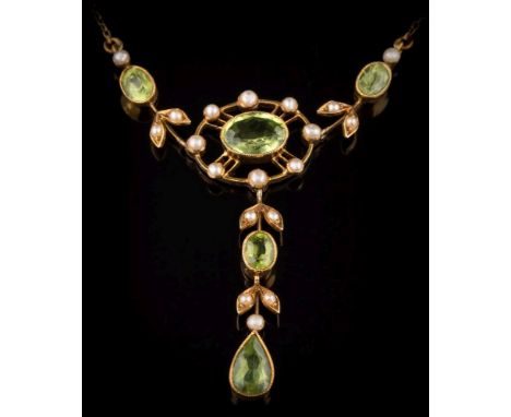 An Edwardian peridot and seed pearl lavalier: the central, oval peridot approximately 9mm long x 6.5mm wide x 3.8mm deep, wit