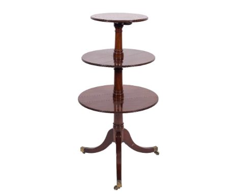 A Regency mahogany circular three tier graduated dumb waiter:, the hinged tops with moulded edges, having ring turned upright
