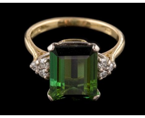 An 18ct gold, green tourmaline and diamond ring: the rectangular tourmaline approximately 11m long x 8.5mm wide x 4.5mm deep,