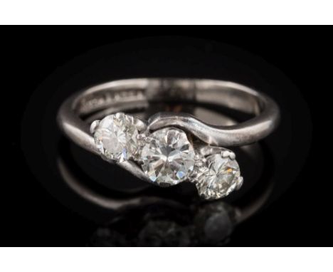 A diamond mounted three-stone crossover ring: with circular brilliant-cut diamonds approximately 0.25ct, 0.4ct and 0.25ct res