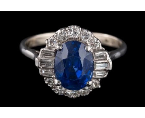 A fine sapphire and diamond oval cluster ring: with central oval sapphire 9.2mm long x 6.8mm wide x 6.5mm deep, estimated to 