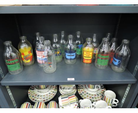 A selection of vintage advertising milk bottles some with bases cut out for light shades