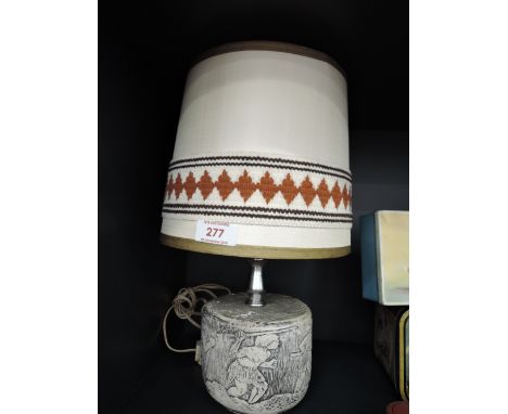 A vintage 70's style plaster cast lamp base with cave men scene
