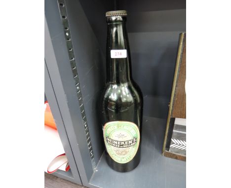 A large vintage Heineken advertising bottle