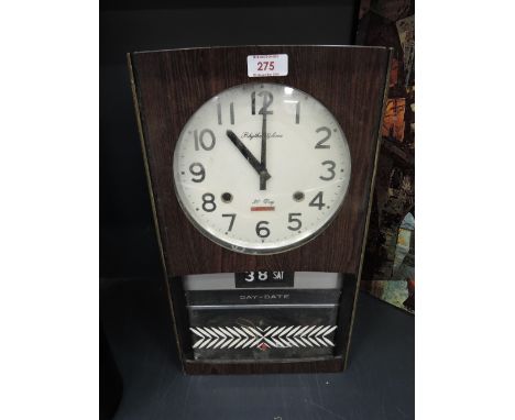 A vintage wall mounted day and date flip clock by Rhythm Gloria 60's design