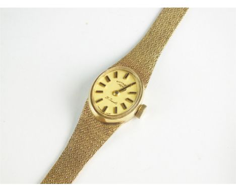 A Lady's 9ct gold Rotary bracelet watch, the oval champagne dial with batons, manual wind, with integral 9ct gold textured br