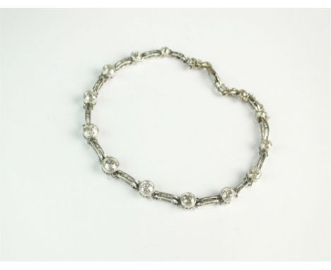 A diamond set bracelet, designed as fourteen old cut milligrain set diamonds each interspersed with a pierced domed link, all