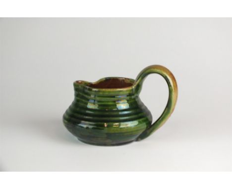 Edwin Beer Fishley (1832-1911) an Arts &amp; Crafts Fremington Pottery green glazed and ribbed jug of squat form, incised mar