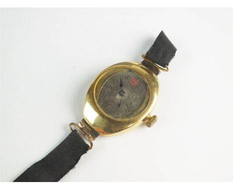 A lady's yellow metal wristwatch, stamped '18k', the oblong grey dial with red and black Arabic numerals, manual wind, revers