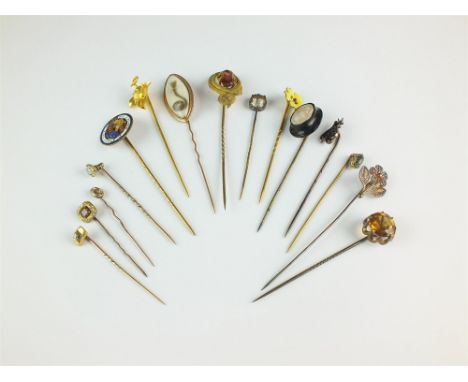 A collection of fifteen stick pins, to include; a yellow metal beetle and leaf example, a navette shaped mourning example and